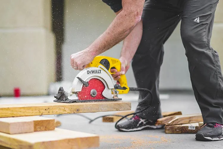 man using electric hand saw